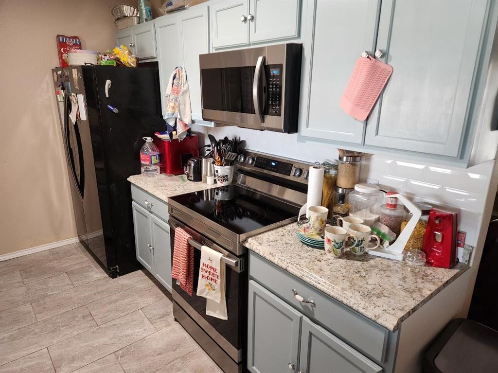 541 Bakers Branch Road Waxahachie, TX 75167 - Photo 7 of 13 a kitchen with stainless steel appliances granite countertop a sink stove and refrigerator