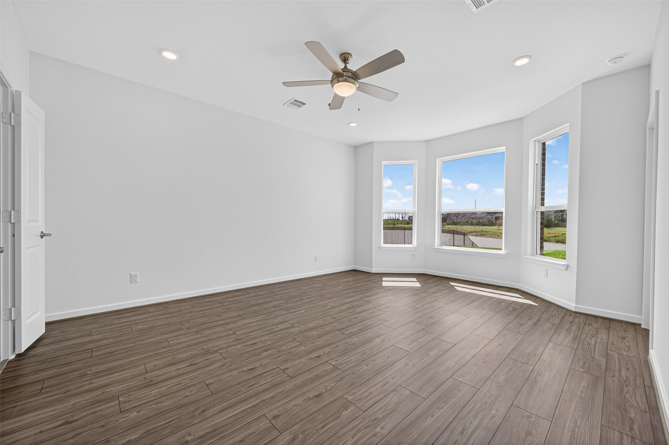 4702 Rustic Grv Lane Fulshear, TX 77441 - Photo 24 of 37 an empty room with wooden floor fan and windows