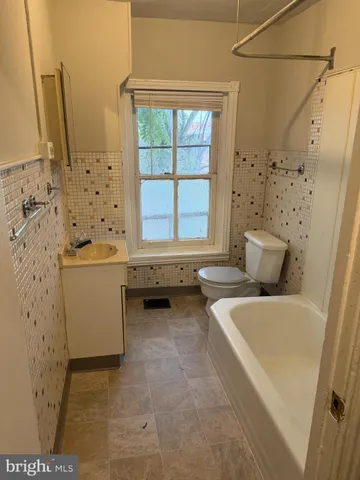 a bathroom with a tub sink and mirror