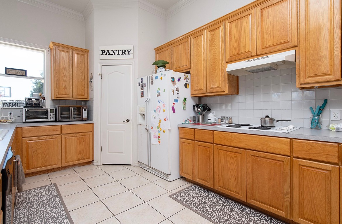 1833 County Road 305 Jarrell, TX 76537 - Photo 24 of 40 a kitchen with stainless steel appliances a refrigerator sink and cabinets