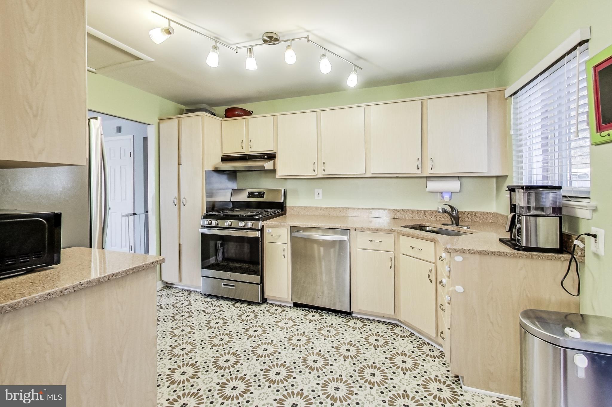 9512 Flower Avenue Silver Spring, MD 20901 - Photo 12 of 41 a kitchen with granite countertop a stove a sink and a refrigerator