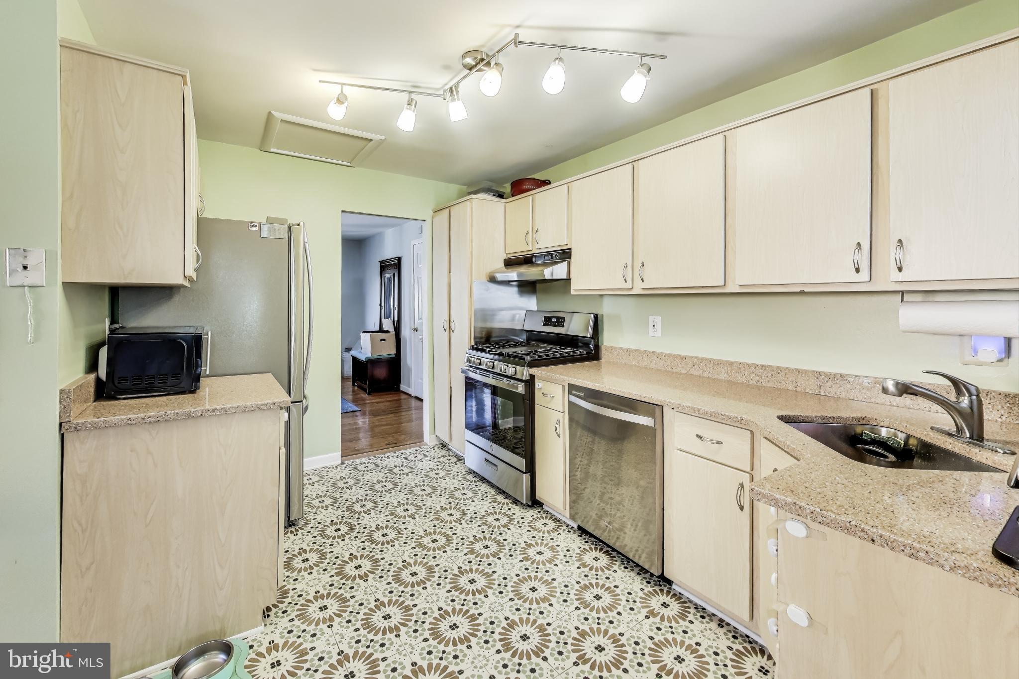 9512 Flower Avenue Silver Spring, MD 20901 - Photo 13 of 41 a kitchen with a sink a refrigerator and cabinets