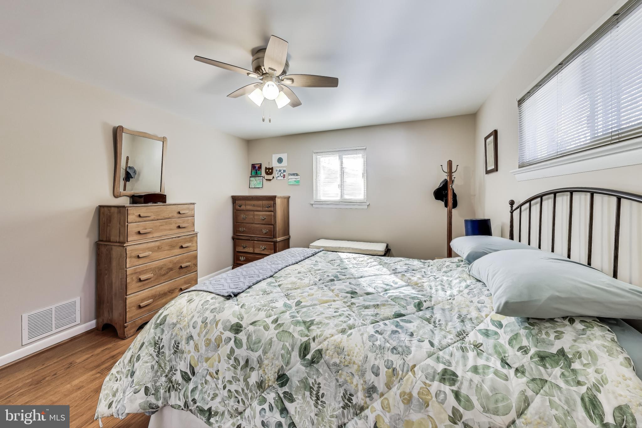 9512 Flower Avenue Silver Spring, MD 20901 - Photo 18 of 41 a bedroom with a bed a dresser and chandelier