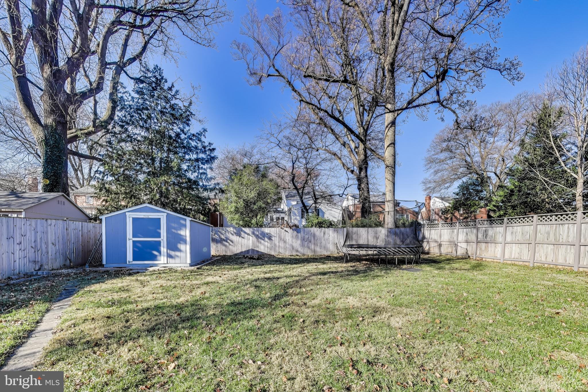 9512 Flower Avenue Silver Spring, MD 20901 - Photo 38 of 41 a view of a backyard with large trees and wooden fence