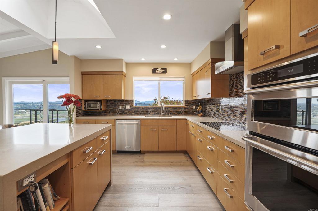 656 Canyon Drive Solana Beach, CA 92075 - Photo 15 of 29 a large kitchen with stainless steel appliances kitchen island granite countertop a stove a sink and a microwave