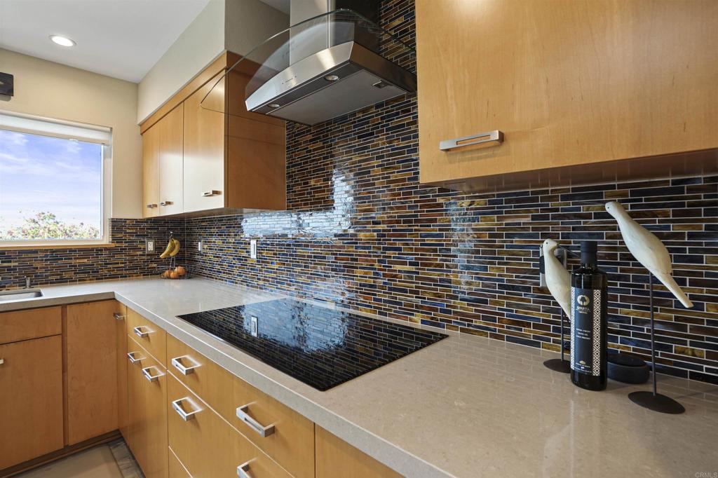 656 Canyon Drive Solana Beach, CA 92075 - Photo 16 of 29 a kitchen with granite countertop a sink a stove and wooden cabinets