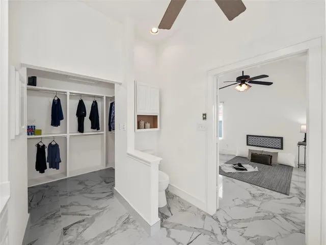 a view of a hallway with bathroom and mirror