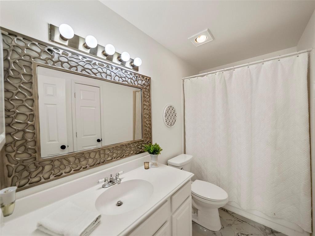 4818 Mize Court Rowlett, TX 75088 - Photo 13 of 21 a bathroom with a sink a toilet and a mirror