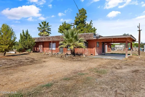 a view of a house with a yard and potted plants