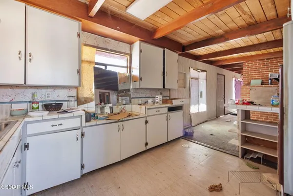 a kitchen with white cabinets and white appliances