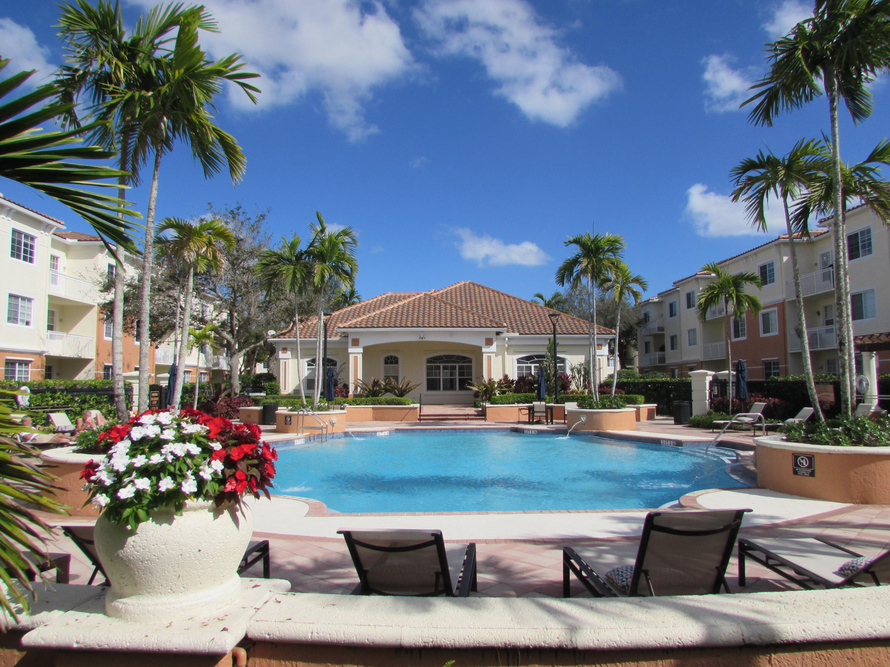 9873 Baywinds Boulevard, Unit 5107 West Palm Beach, FL 33411 - Photo 1 of 22 a front view of a house with yard and sitting area