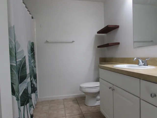 a bathroom with a granite countertop toilet and a sink