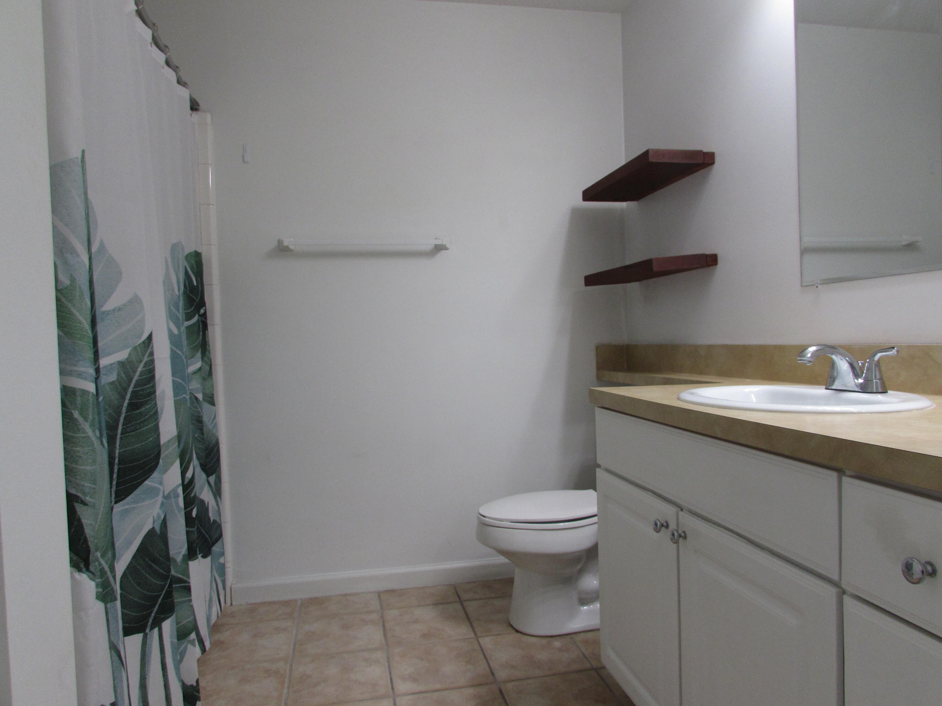 9873 Baywinds Boulevard, Unit 5107 West Palm Beach, FL 33411 - Photo 12 of 22 a bathroom with a granite countertop toilet and a sink