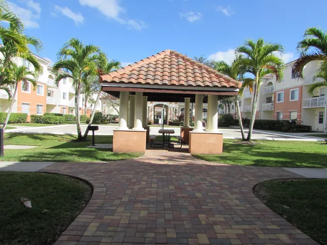 a front view of a house with garden and sitting area
