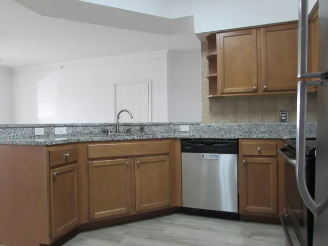 a kitchen with granite countertop cabinets stainless steel appliances and a sink