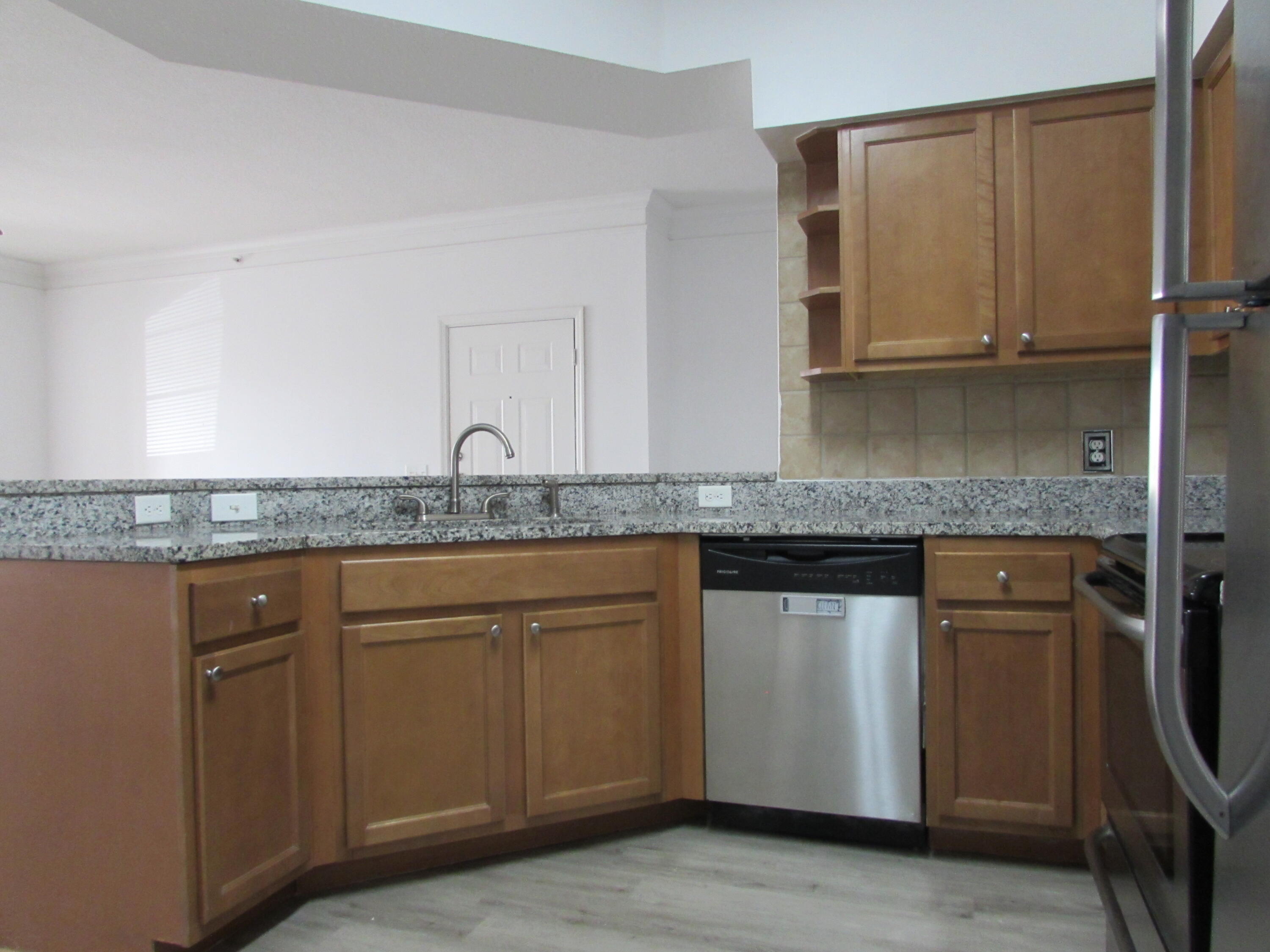 9873 Baywinds Boulevard, Unit 5107 West Palm Beach, FL 33411 - Photo 2 of 22 a kitchen with granite countertop cabinets stainless steel appliances and a sink