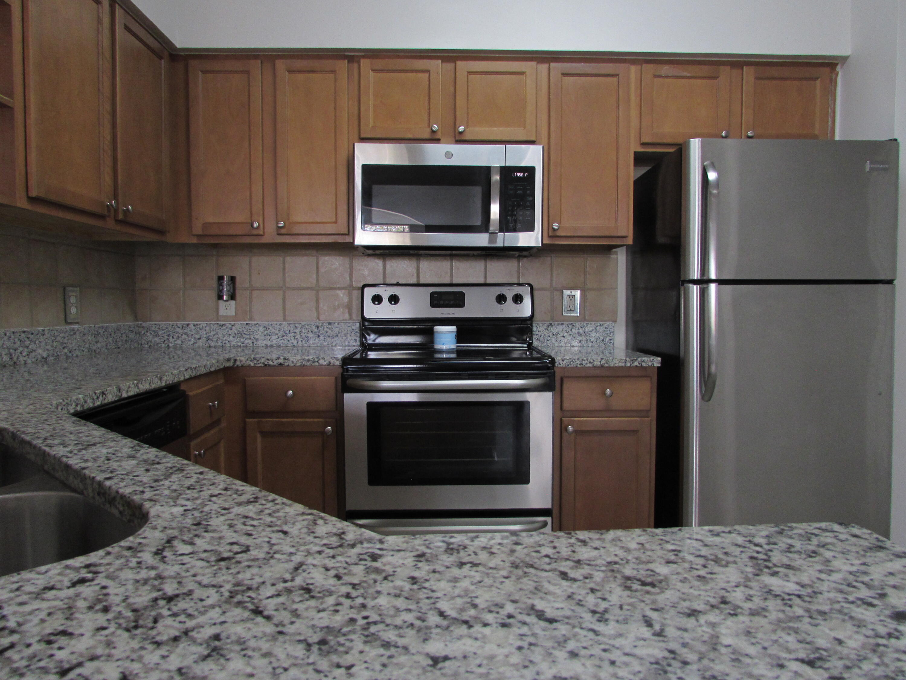 9873 Baywinds Boulevard, Unit 5107 West Palm Beach, FL 33411 - Photo 4 of 22 a kitchen with a stove and a refrigerator