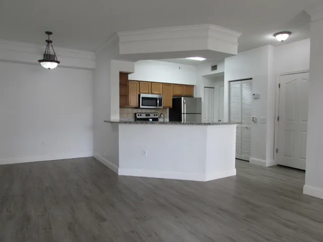 a view of a kitchen with a sink wooden floor and a refrigerator