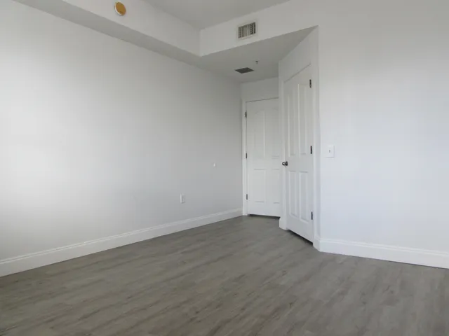 a view of an empty room with wooden floor