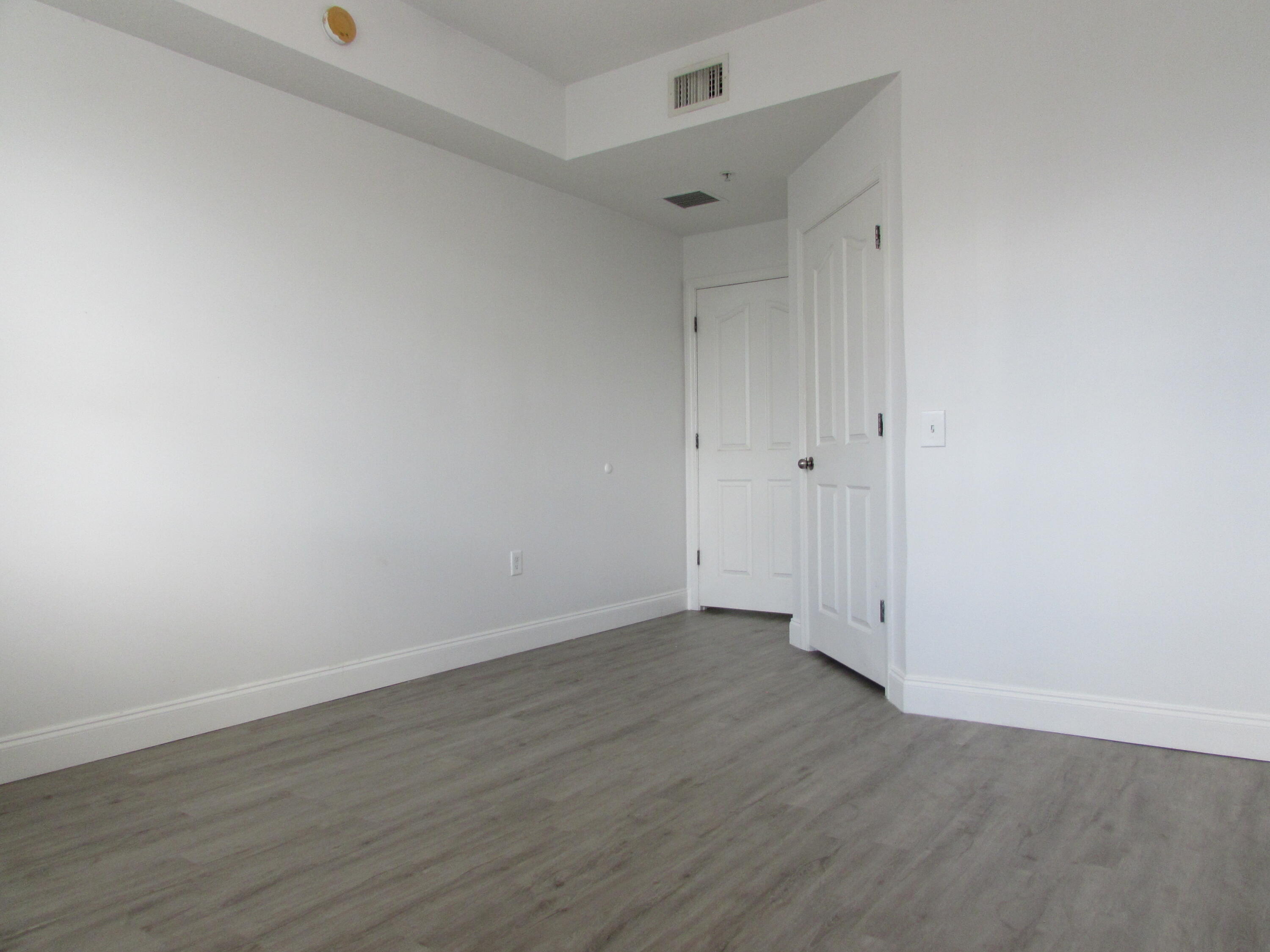 9873 Baywinds Boulevard, Unit 5107 West Palm Beach, FL 33411 - Photo 8 of 22 a view of an empty room with wooden floor