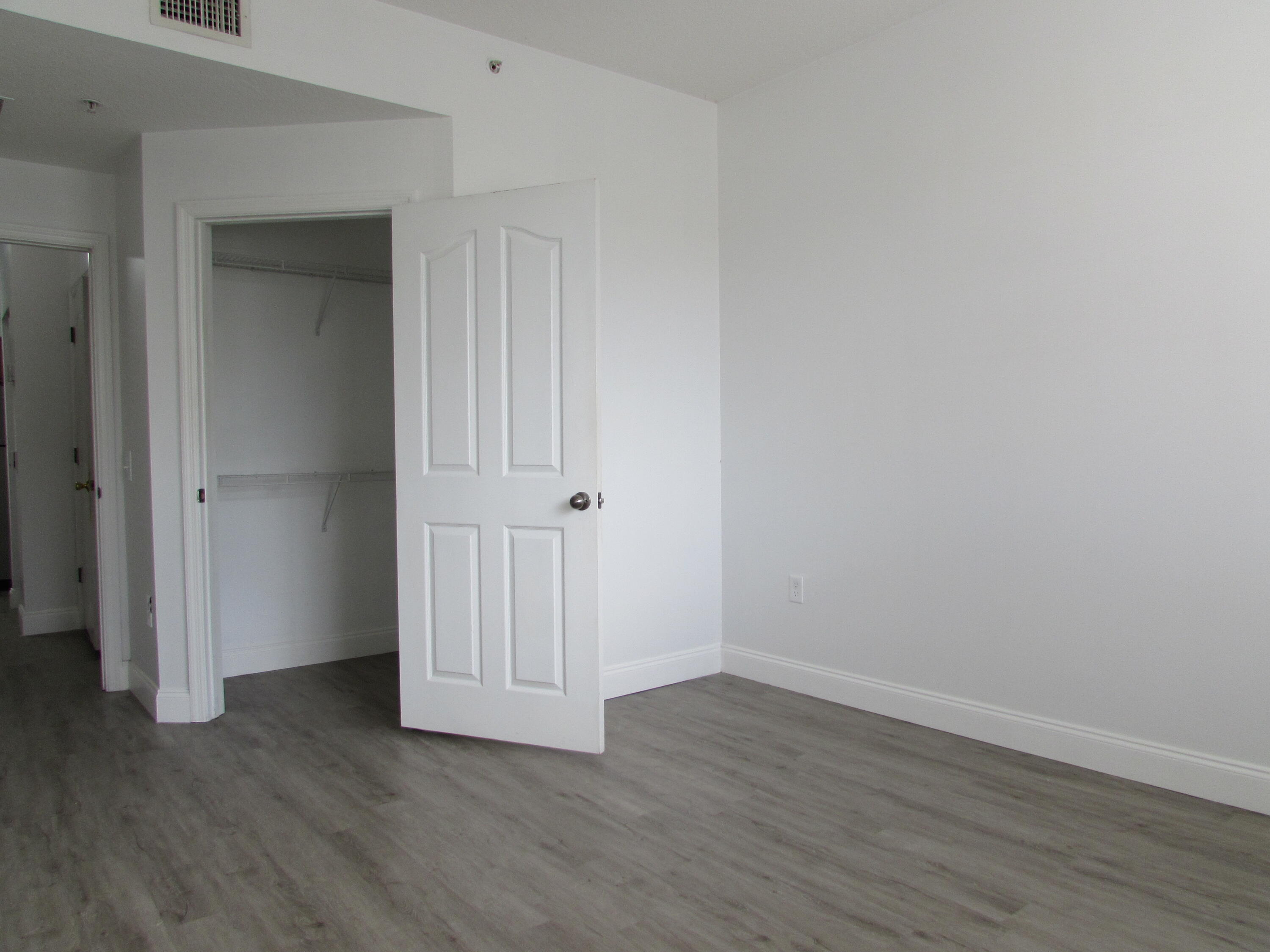 9873 Baywinds Boulevard, Unit 5107 West Palm Beach, FL 33411 - Photo 10 of 22 a view of an empty room with wooden floor