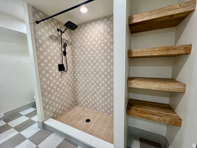 812 East Bates Cyn Road Tooele, UT 84074 - Photo 83 of 144 Walk-in shower featuring patterned wall tiles, a rainfall showerhead, and a handheld sprayer with matte black finishes