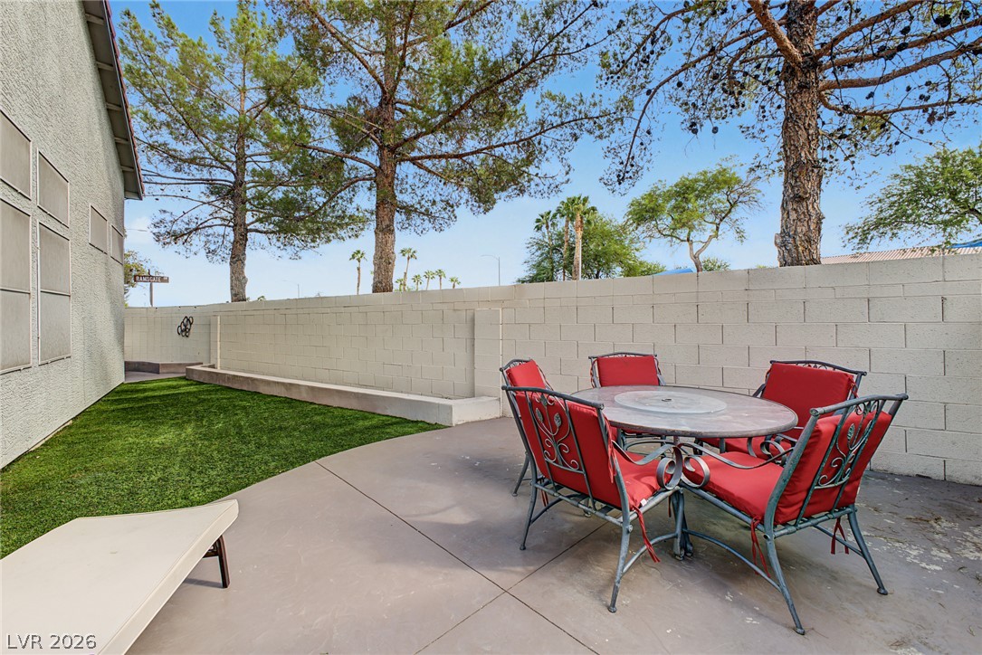 2376 Ramsgate Drive Henderson, NV 89074 - Photo 22 of 25 Mature trees rise above the private block fence bordering this low-maintenance concrete patio.