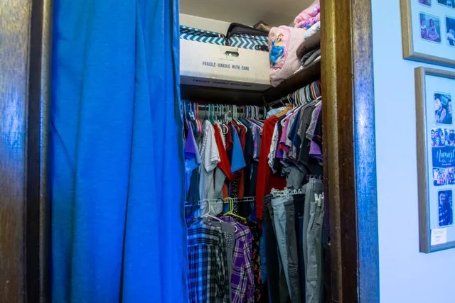 a view of walk in closet with clothes