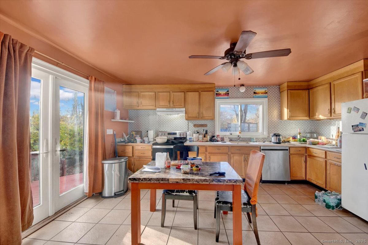 375 Silver Street Bridgeport, CT 06610 - Photo 11 of 21 a kitchen with kitchen island a stove a sink a dining table and chairs