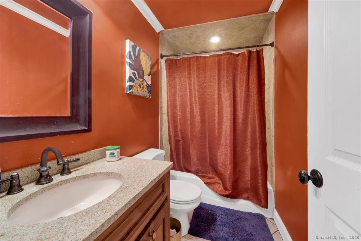 375 Silver Street Bridgeport, CT 06610 - Photo 16 of 21 a bathroom with a granite countertop sink and a mirror