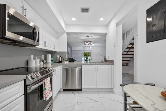 a kitchen with stainless steel appliances granite countertop a stove a sink and a microwave