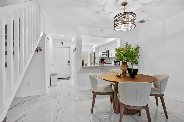 a dining room with furniture a chandelier and wooden floor
