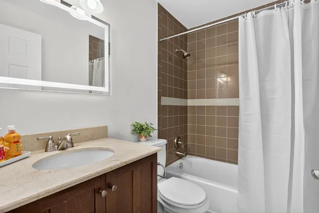 a bathroom with a sink toilet a mirror and shower