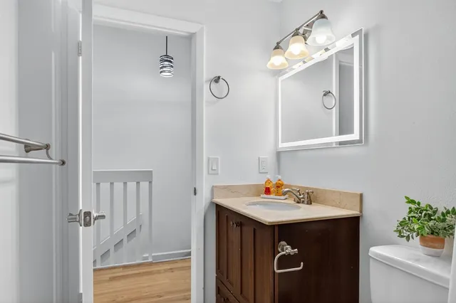 a bathroom with a sink a light fixture and a mirror