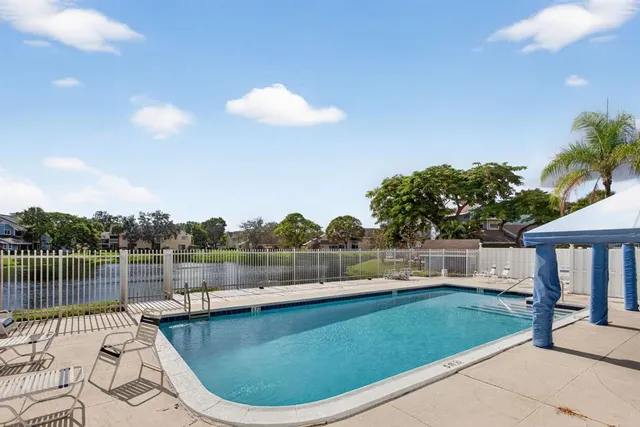 a view of a swimming pool with a patio and a garden