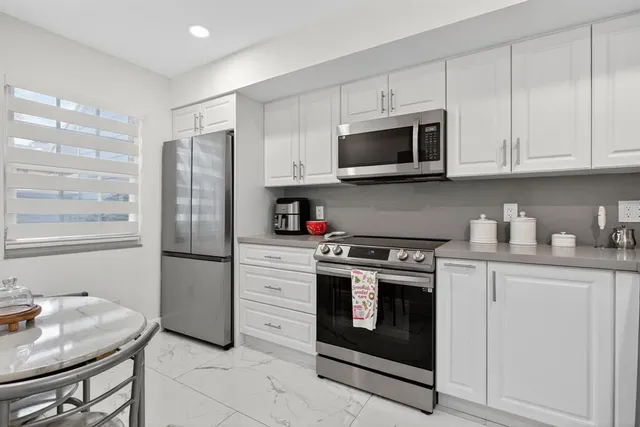 a kitchen with stainless steel appliances granite countertop a stove a refrigerator and a microwave