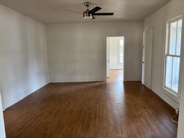 811 West 8th Street Cisco, TX 76437 - Photo 11 of 22 an empty room with wooden floor fan and windows