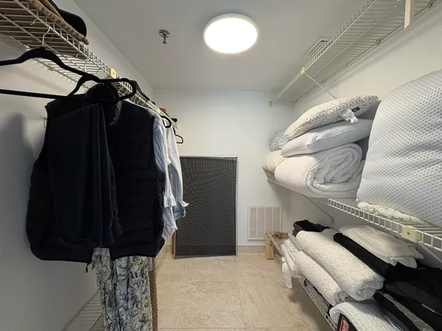 a view of walk in closet with clothes and shoes