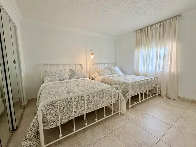 a bedroom with two beds and a window