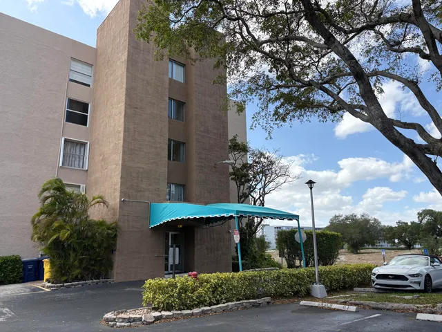 a view of a white house with a tree