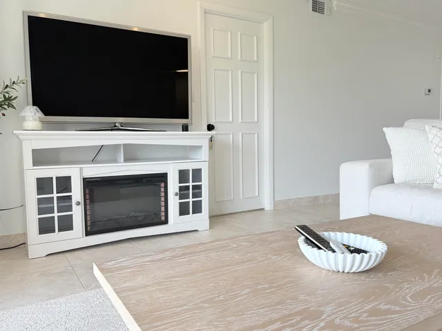 a living room with a fireplace and a flat screen tv