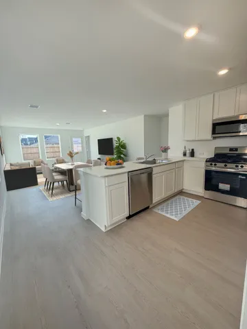 a large white kitchen with cabinets and stainless steel appliances
