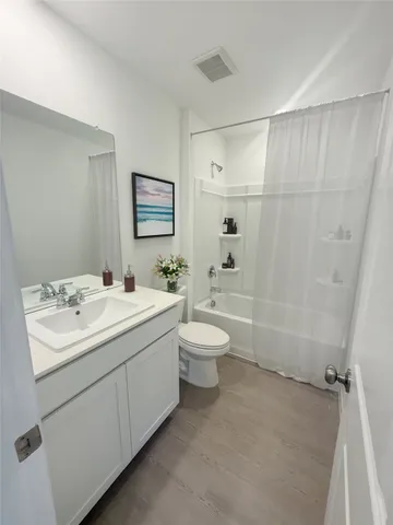 a bathroom with a double vanity sink toilet and shower