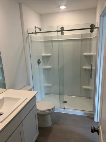 a bathroom with a shower a toilet and a sink