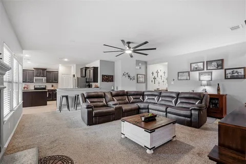 a living room with furniture kitchen view and a window