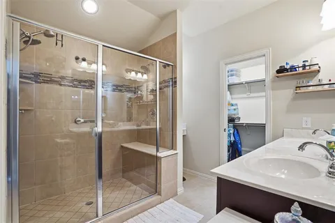 a bathroom with a shower sink and mirror