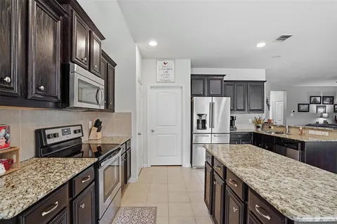 a kitchen with granite countertop stainless steel appliances and wooden cabinets