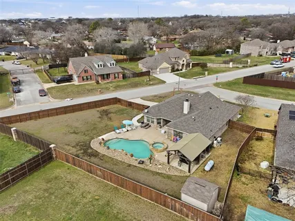 an aerial view of a house with yard swimming pool and mountains
