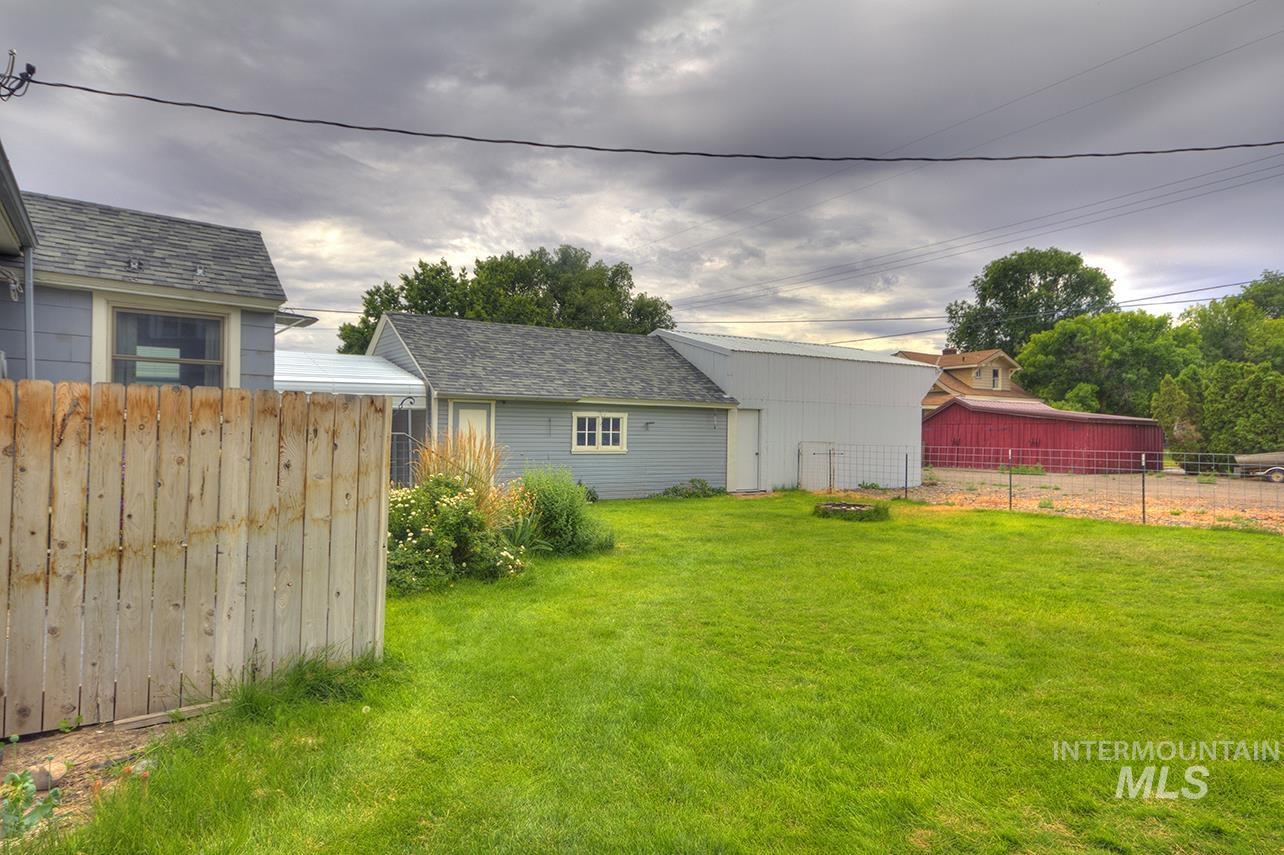 351 West Main Street South Vale, OR 97918 - Photo 26 of 33 Expansive fenced yard featuring a green lawn, established landscaping, and a shed with a gray shingle roof