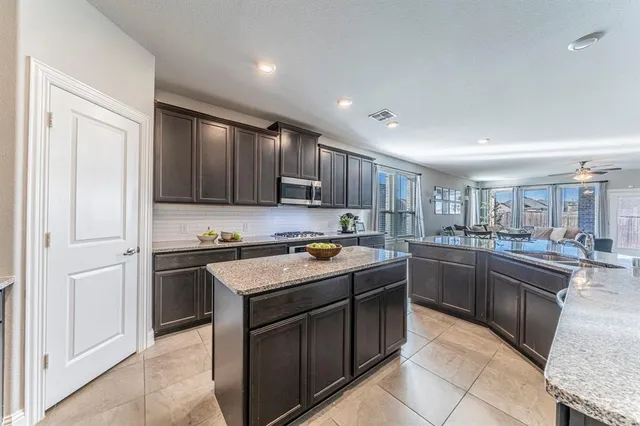 a kitchen with stainless steel appliances granite countertop a stove top oven a sink and dishwasher